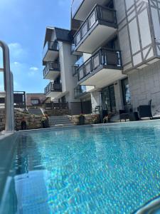 uma piscina em frente a um edifício em Five Seasons Szklarska Poręba em Szklarska Poręba