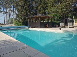 - une piscine avec un kiosque en arrière-plan dans l'établissement Le Spa du Cabanon: Cabanon de luxe avec Spa entièrement privatif, à Aye