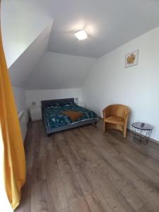 ein Schlafzimmer mit einem Bett und einem Stuhl in einem Zimmer in der Unterkunft Dom przy Zagrodzie in Nowy Targ