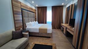 Habitación de hotel con cama y sofá en Hilal Palace - Halal en Golem