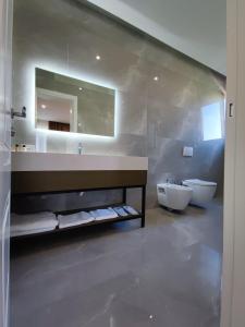 La salle de bains est pourvue d'un lavabo, de toilettes et d'un miroir. dans l'établissement Hilal Palace - Halal, à Golem