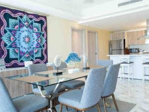 uma sala de jantar com uma mesa de vidro e cadeiras em Exclusive brand new 3BR condo at Cap Cana em Punta Cana