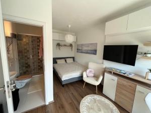 mały salon z łóżkiem i telewizorem w obiekcie Lila Apartman w Balatonföldvárze