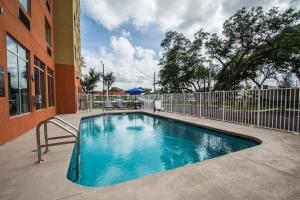 une piscine devant un immeuble dans l'établissement Comfort Suites Fort Lauderdale Airport South & Cruise Port, à Dania Beach