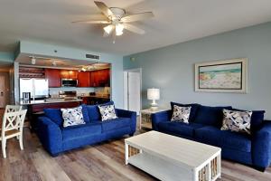 una sala de estar con 2 sofás azules y una mesa. en Laketown Wharf 1523 en Panama City Beach