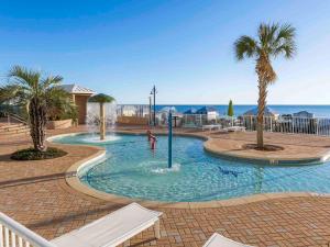 a pool with palm trees and a person playing in it at Laketown Wharf 1523 in Panama City Beach