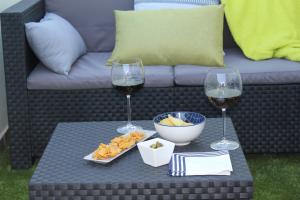 una mesa con dos copas de vino y un tazón de queso en Balcondel Turia en Villastar
