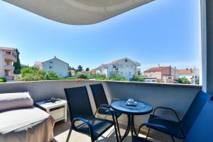 balkon z łóżkiem, krzesłami i stołem w obiekcie Apartment South w mieście Zadar
