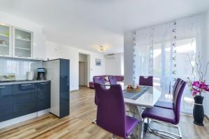 kuchnia i jadalnia z purpurowymi krzesłami i stołem w obiekcie Apartment South w mieście Zadar