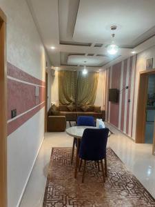 a living room with a table and chairs and a couch at LH résidence mezouar1 appartement 4 in Laayoune
