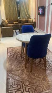 a table and two blue chairs in a living room at LH résidence mezouar1 appartement 4 in Laayoune