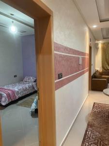a room with a bedroom with a bed and a couch at LH résidence mezouar1 appartement 4 in Laayoune