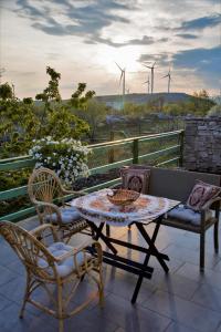 un tavolo e sedie su un balcone con turbine eoliche di Planinska kuća Agroturizam Kućica Mostar a Mostar