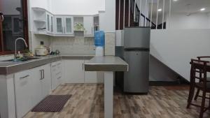 a kitchen with white cabinets and a sink and a staircase at LEO-BREEZE Apartments in Kurunegala