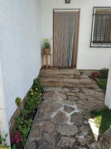 una pasarela de piedra que conduce a la puerta de una casa en La lechuza blanca, en Casavieja