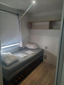 een kleine kamer met een bed in een kamer bij Mobil-home premium 325 in Narbonne