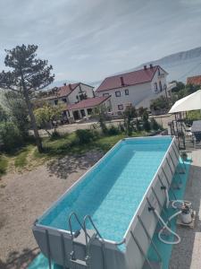 a large swimming pool in a yard next to a house at Apartments Vita in Novi Vinodolski