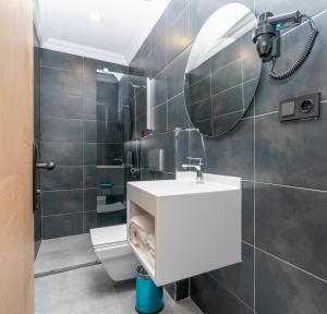 y baño con lavabo blanco y espejo. en 216 Center Suite, en Estambul