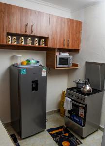 een kleine keuken met een koelkast en een fornuis bij Sparkle Homes 