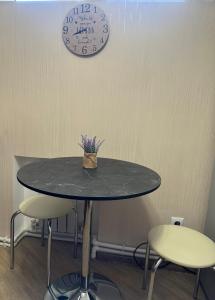 una mesa con dos sillas y un reloj en la pared en Brand new comfortable apartments in Sevan city, en Sevan