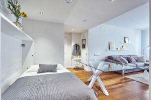 1 dormitorio con cama y mesa de cristal en Sweet Inn - Paseo de Gracia - City Centre, en Barcelona