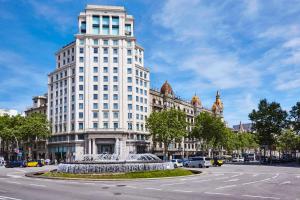 ein großes weißes Gebäude mit einem Brunnen davor in der Unterkunft Sweet Inn - Paseo de Gracia - City Centre in Barcelona