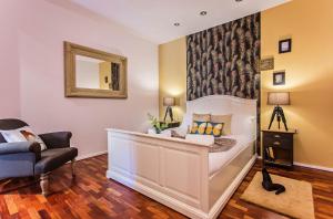 1 dormitorio con cama, silla y espejo en Sweet Inn - Dali Apartment Gracia, en Barcelona