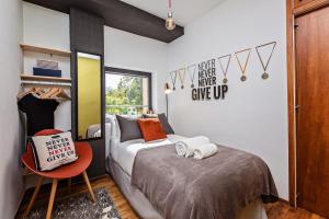 バルセロナにあるSweet Inn - Bogatell Beachのベッドルーム1室(ベッド1台、赤い椅子付)