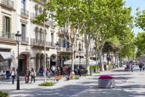 Gente caminando por una calle en una ciudad con edificios en Sweet Inn - Dali Apartment Gracia, en Barcelona