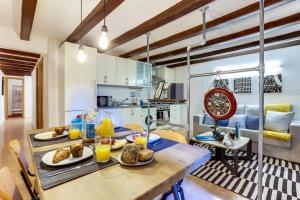 una cocina y una sala de estar con una mesa con comida. en Sweet Inn - Miro Park, en Barcelona