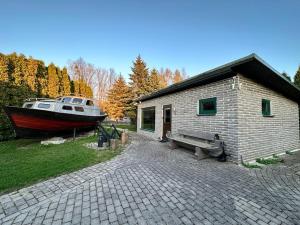 a small building with a boat next to it at 100SaulesVikingi in Grobiņa