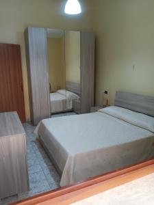 a bedroom with two beds and a large mirror at Vacanze a Solanas.....con Clima in Solanas