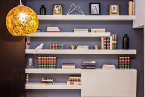 a library with white shelves filled with books at Sweet Inn - Urqui City Center in Barcelona