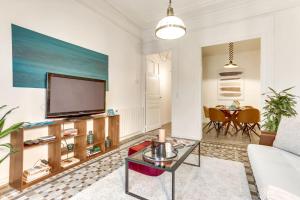 a living room with a television and a table at Sweett - Aragon in Barcelona