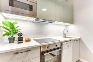 a white kitchen with a sink and a microwave at Sweett - Aragon in Barcelona