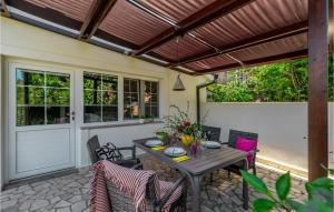 a patio with a wooden table and chairs at Awesome Home In Medulin With Kitchen in Medulin