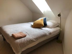a bed with two pillows on it in a room at Bienvenue pour vous détendre in Parbayse
