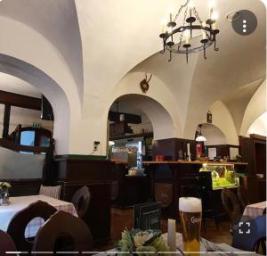 a restaurant with a chandelier and a table with a glass of beer at Gasthof zum Greif in Leoben