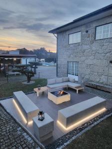 um pátio com sofás e uma fogueira em frente a um edifício em Villa Moura - Pool & Jacuzzi em Póvoa de Lanhoso