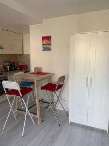 een keuken met een tafel en 2 stoelen bij Charmant studio in La Rochelle