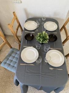 una mesa con platos y copas de vino. en Уютная квартира с двумя спальными en Qiryat H̱ayyim