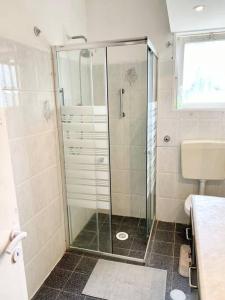 a shower with a glass door in a bathroom at Уютная квартира с двумя спальными in Qiryat H̱ayyim