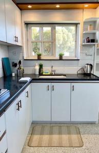 Qiryat H̱ayyimУютная квартира с двумя спальными的厨房配有白色橱柜、水槽和窗户 更多11张照片