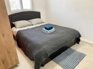 1 dormitorio con 1 cama con 2 toallas en Уютная квартира с двумя спальными en Qiryat H̱ayyim