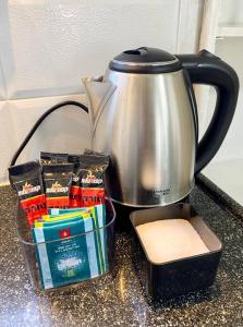 a tea pot on a counter next to a box of packets at Уютная квартира с двумя спальными in Qiryat H̱ayyim