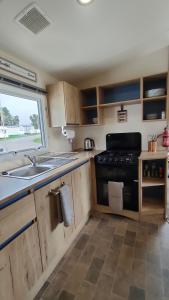 a kitchen with a black stove and a sink at 3 Bedroom Mobile Home - Workers & Vans Not Allowed in Port Seton