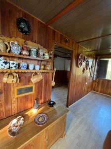 a room with wooden walls and a table with ceramics at Chata na léto in Nespeky