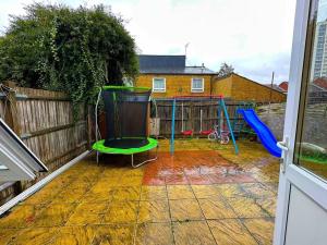 a backyard with a playground with a swing at NEW! 4 Bedroom London House with Garden and Lawn in London