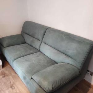 a green couch sitting in a living room at Da Carla Dolomiti Val di Zoldo in Val di Zoldo
