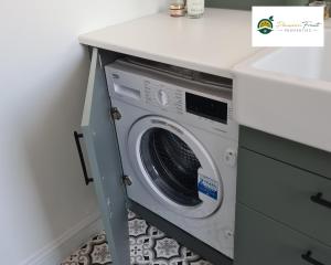 uma máquina de lavar roupa debaixo de um balcão numa cozinha em 2 Bedroom House In Leeds With Free Wi-Fi and Parking 24 WAL em Beeston Hill